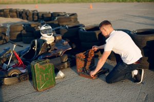 Karting. Man in a white t-shirt. Male refills a car